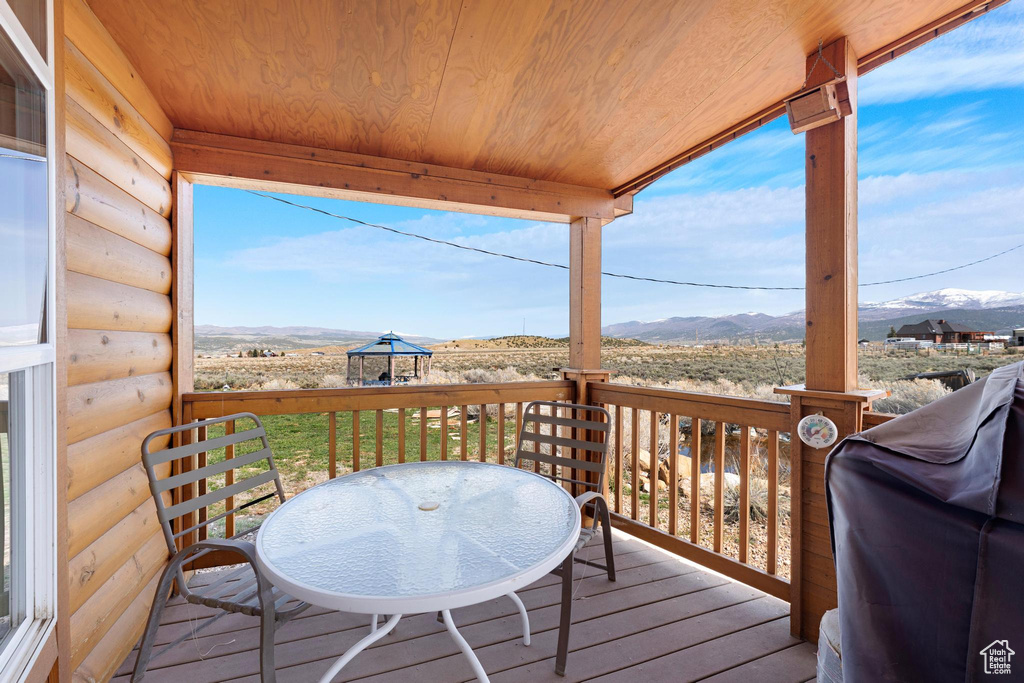Wooden deck with a mountain view and area for grilling