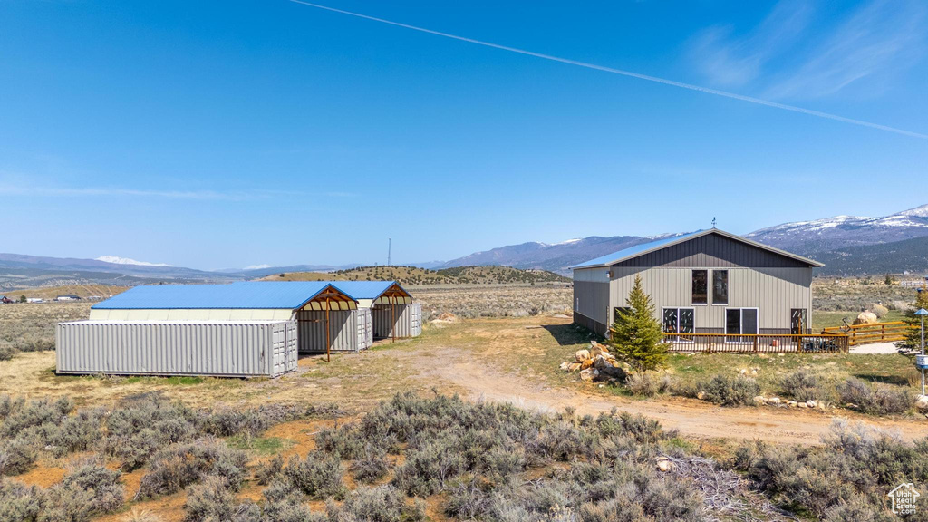 Exterior space with fence, an outdoor structure, a mountain view, and a pole building
