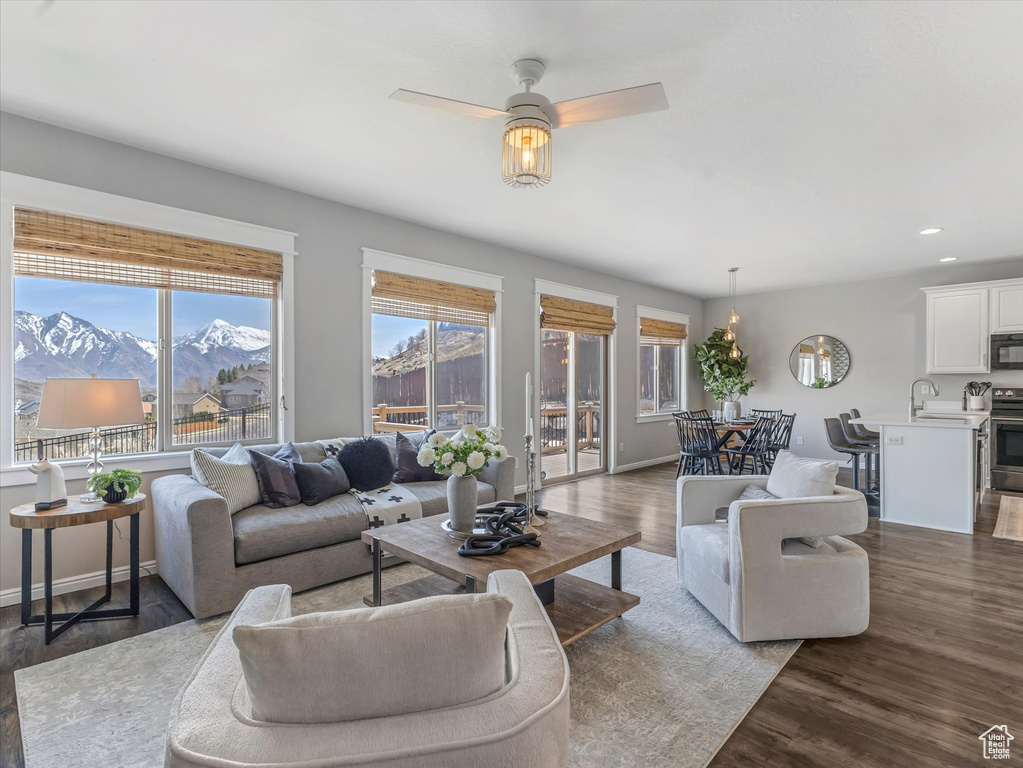 Living area with a mountain view, baseboards, ceiling fan, recessed lighting, and wood finished floors