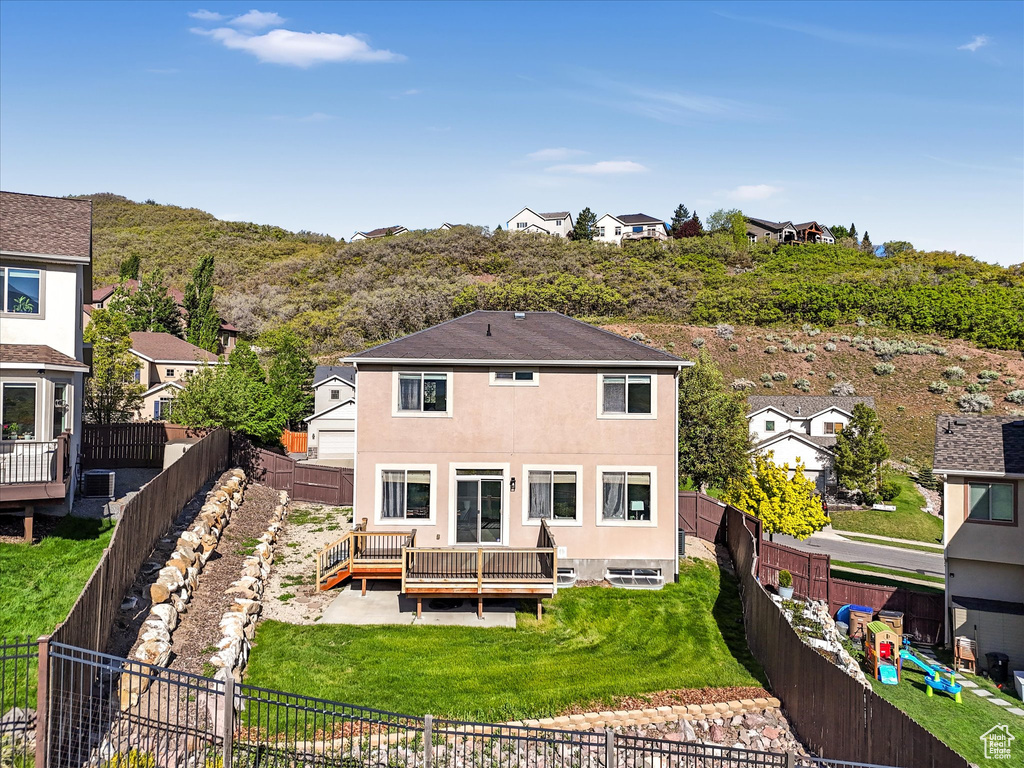 Rear view of property with a deck, stucco siding, and a residential view
