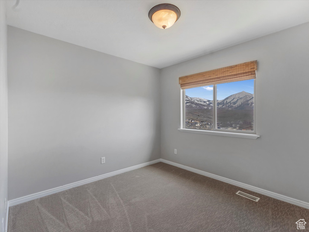 Spare room with visible vents, baseboards, and carpet floors