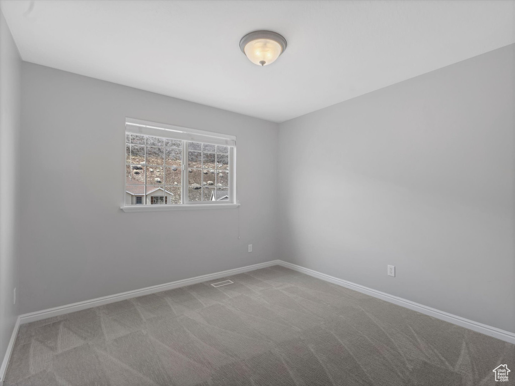 Unfurnished room with visible vents, baseboards, and carpet
