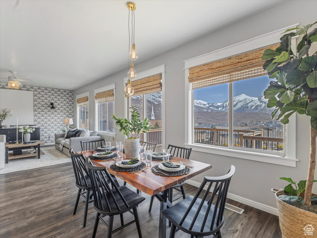 Dining space with ceiling fan, wood finished floors, a mountain view, and baseboards