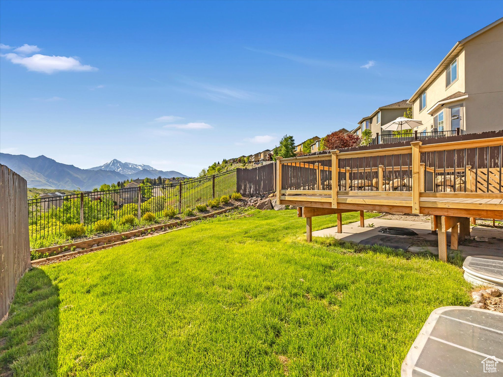 View of yard featuring a deck with mountain view