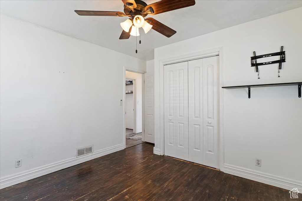 Unfurnished bedroom featuring visible vents, a closet, baseboards, and wood finished floors