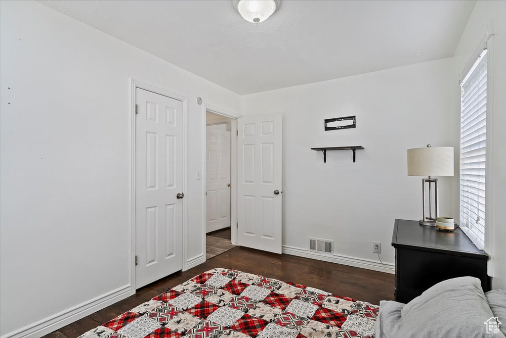 Bedroom with visible vents, baseboards, and wood finished floors