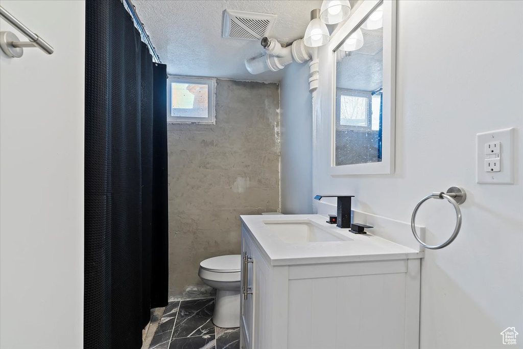 Bathroom with vanity, visible vents, toilet, marble finish floor, and a shower with shower curtain