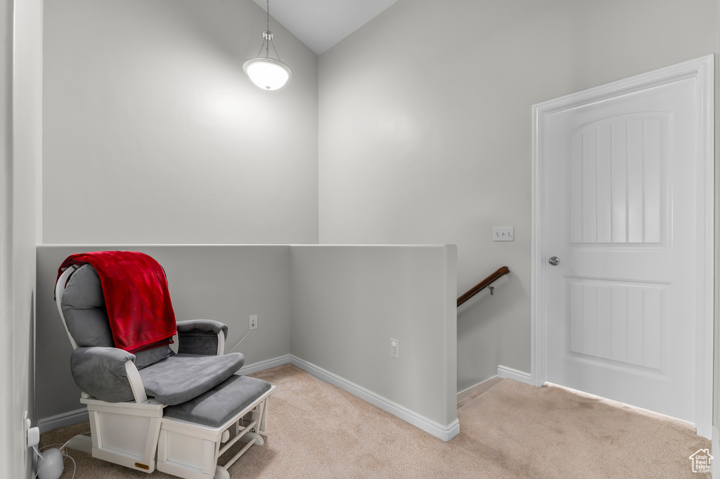 Sitting room featuring baseboards, vaulted ceiling, an upstairs landing, and carpet floors