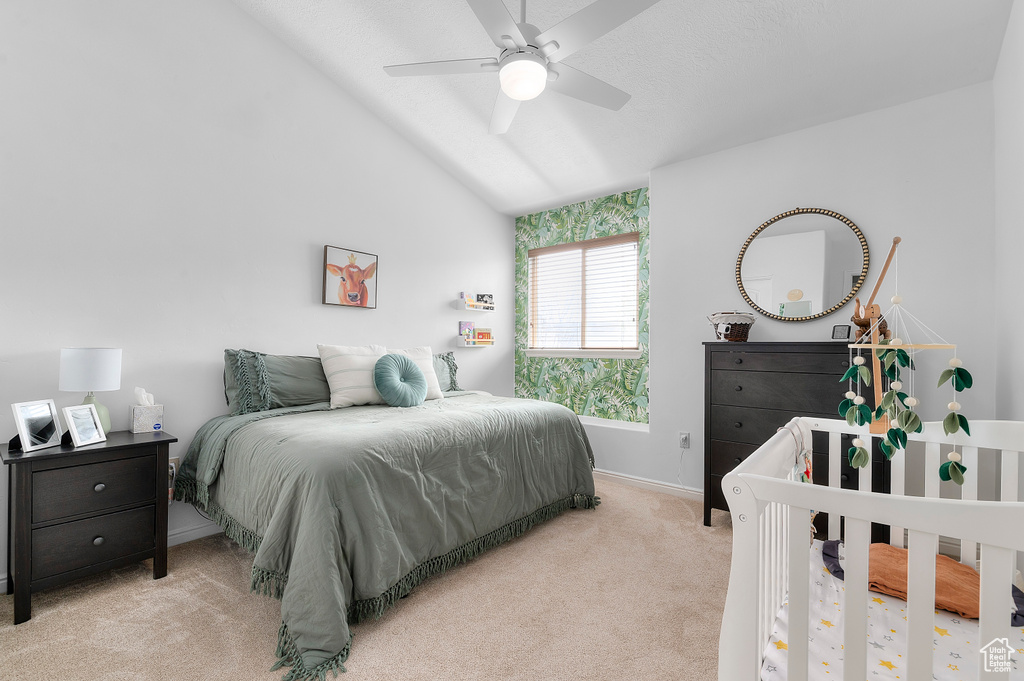 Carpeted bedroom featuring baseboards, a ceiling fan, and vaulted ceiling