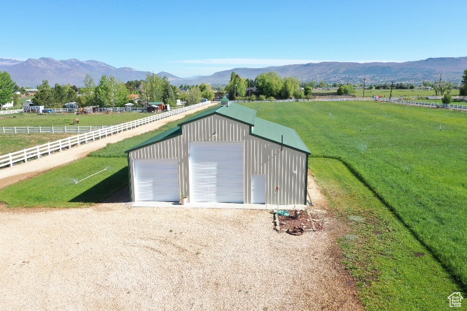 Detached garage with a rural view and a mountain view