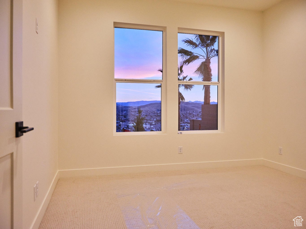 Empty room with carpet flooring, baseboards, and a mountain view