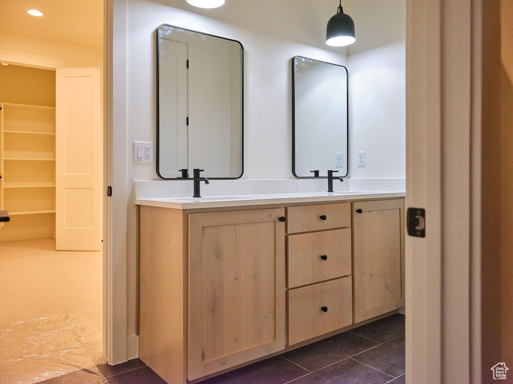 Bathroom featuring tile patterned floors, double vanity, and a sink