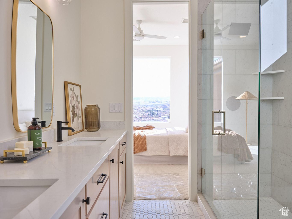 Ensuite bathroom with double vanity, a stall shower, ensuite bath, a ceiling fan, and a sink