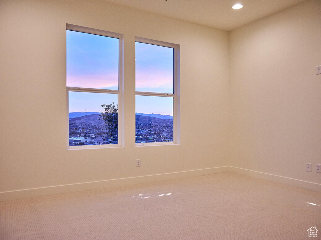 Carpeted spare room featuring a mountain view, baseboards, and recessed lighting