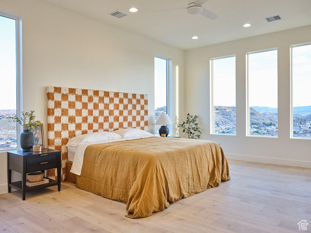 Bedroom with visible vents, multiple windows, and wood finished floors