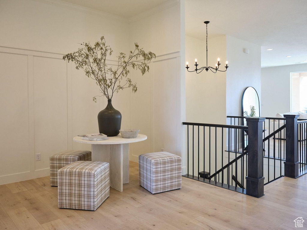 Corridor with an upstairs landing, a chandelier, and wood finished floors