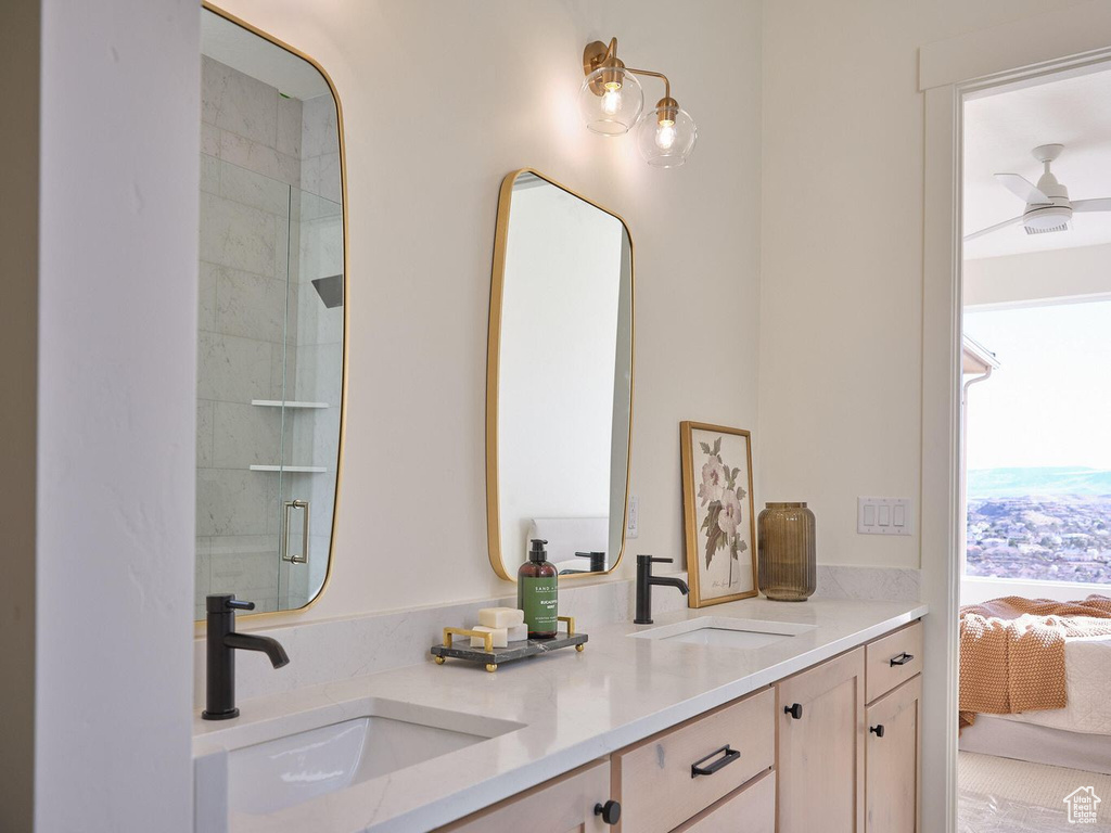 Ensuite bathroom featuring a sink, double vanity, connected bathroom, and a shower with shower door