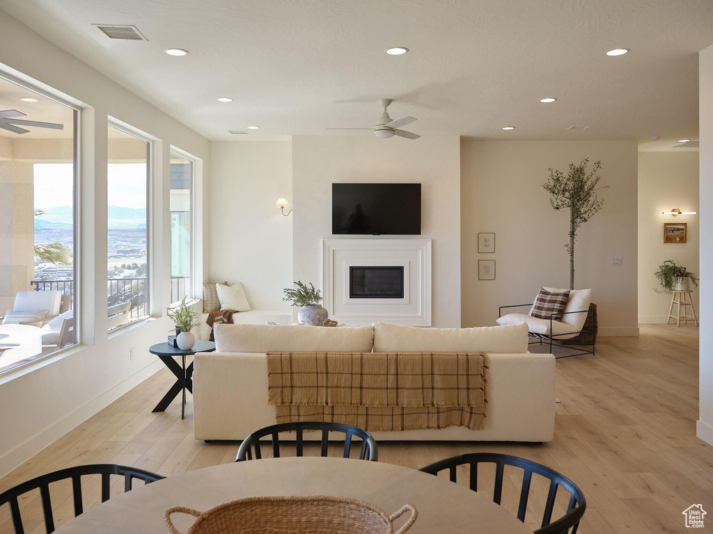 Living area featuring light wood-style floors, recessed lighting, visible vents, and ceiling fan