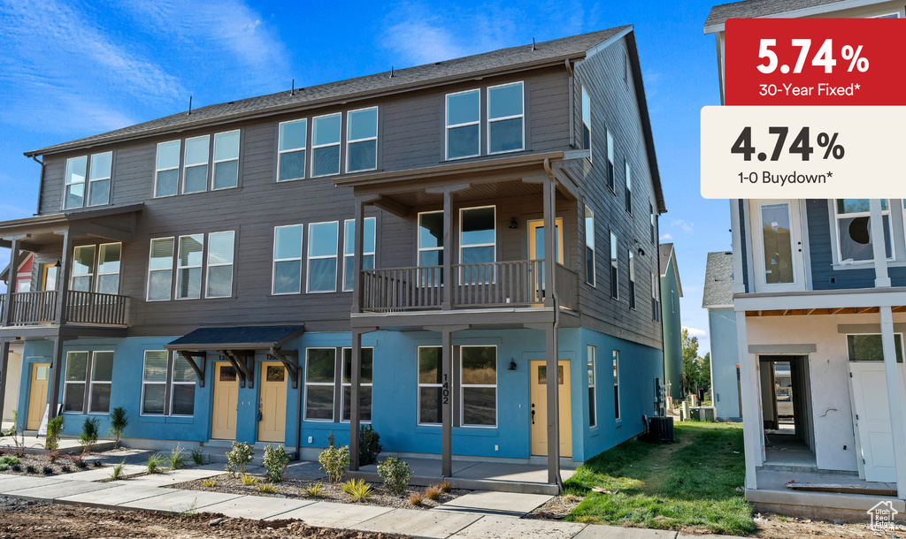 View of front of home featuring cooling unit and a balcony
