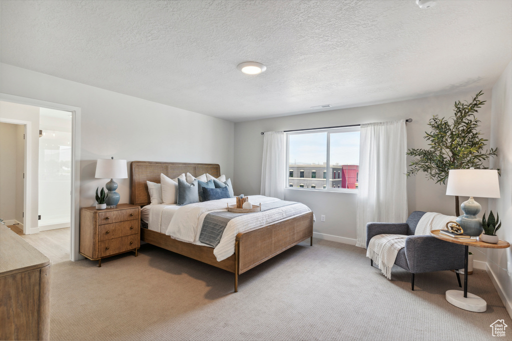 Bedroom with light carpet and a textured ceiling