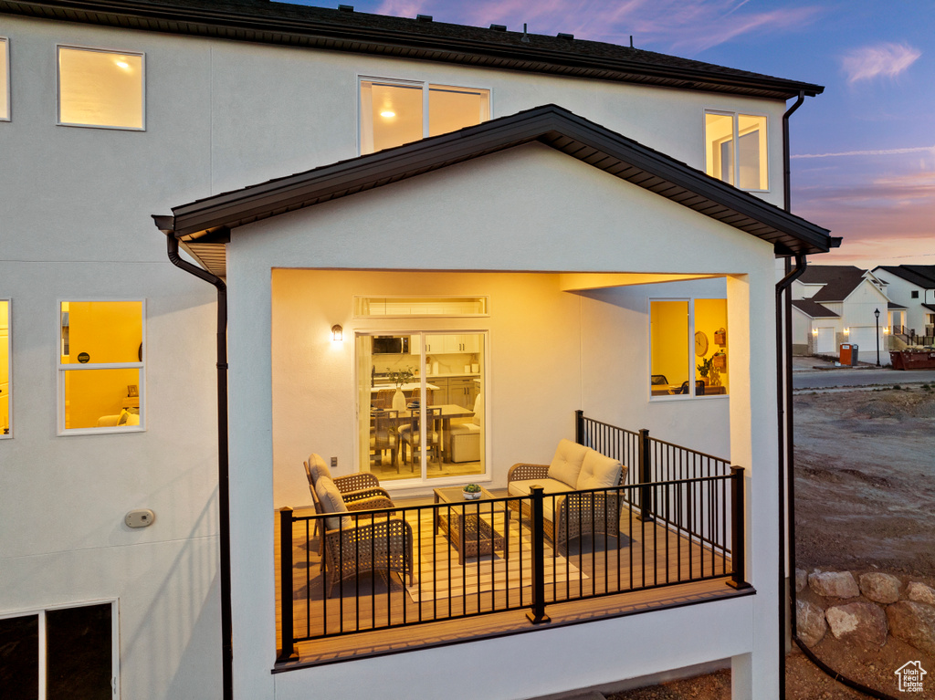 Back of property at dusk featuring stucco siding