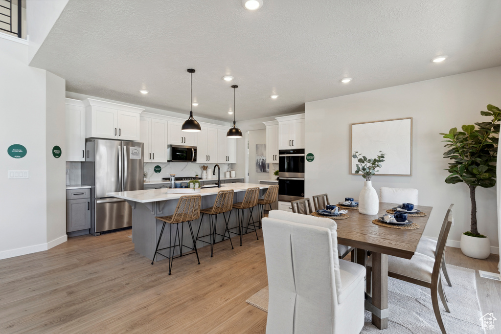 Dining room with light wood-type flooring and recessed lighting
