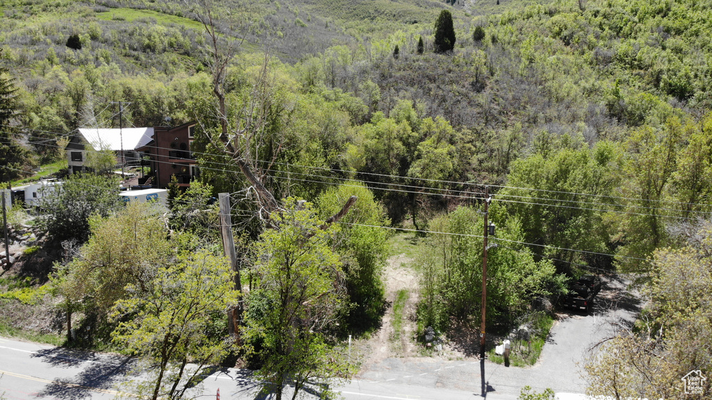 Aerial view of property and surrounding area with a heavily wooded area