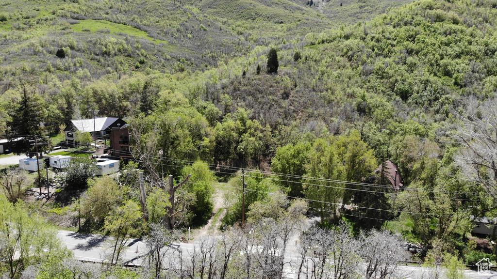Aerial view of property and surrounding area with a heavily wooded area
