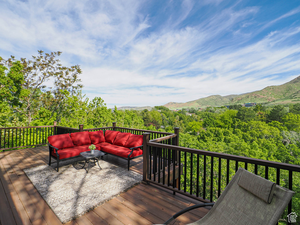 Wooden deck with an outdoor living space and a mountain view
