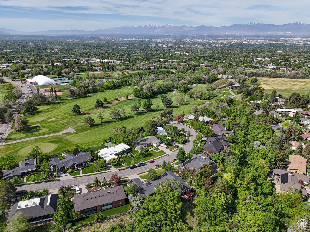 Aerial perspective of suburban area with a mountain backdrop and a local golf course