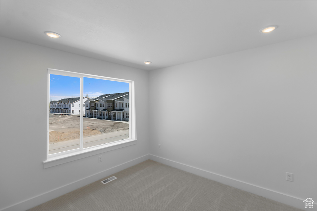 Spare room with visible vents, baseboards, recessed lighting, and light carpet