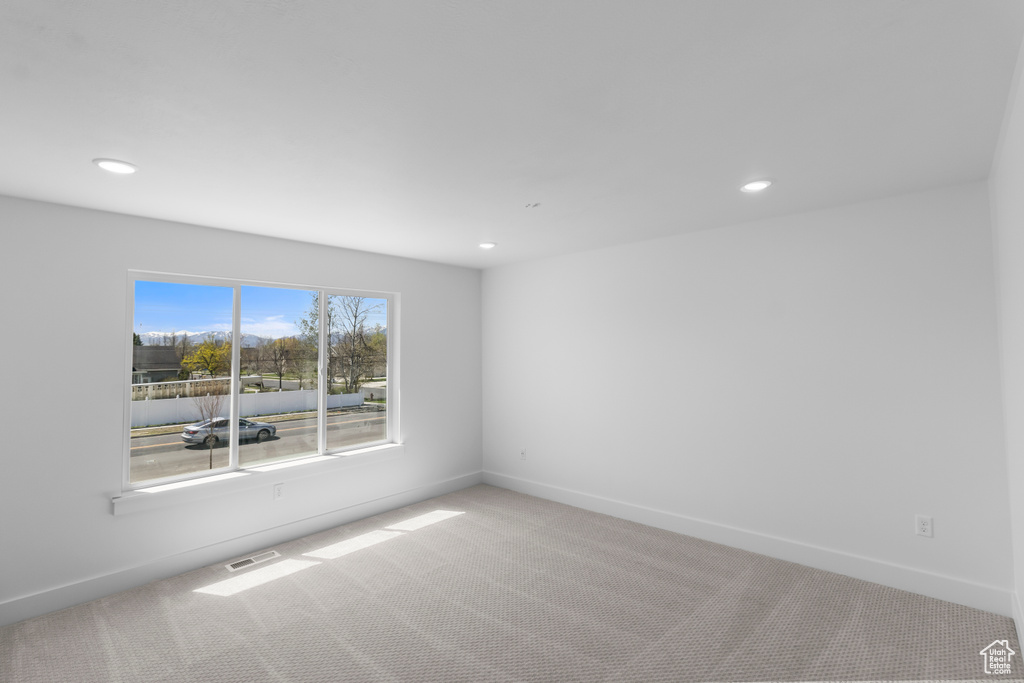 Carpeted empty room with recessed lighting, visible vents, and baseboards