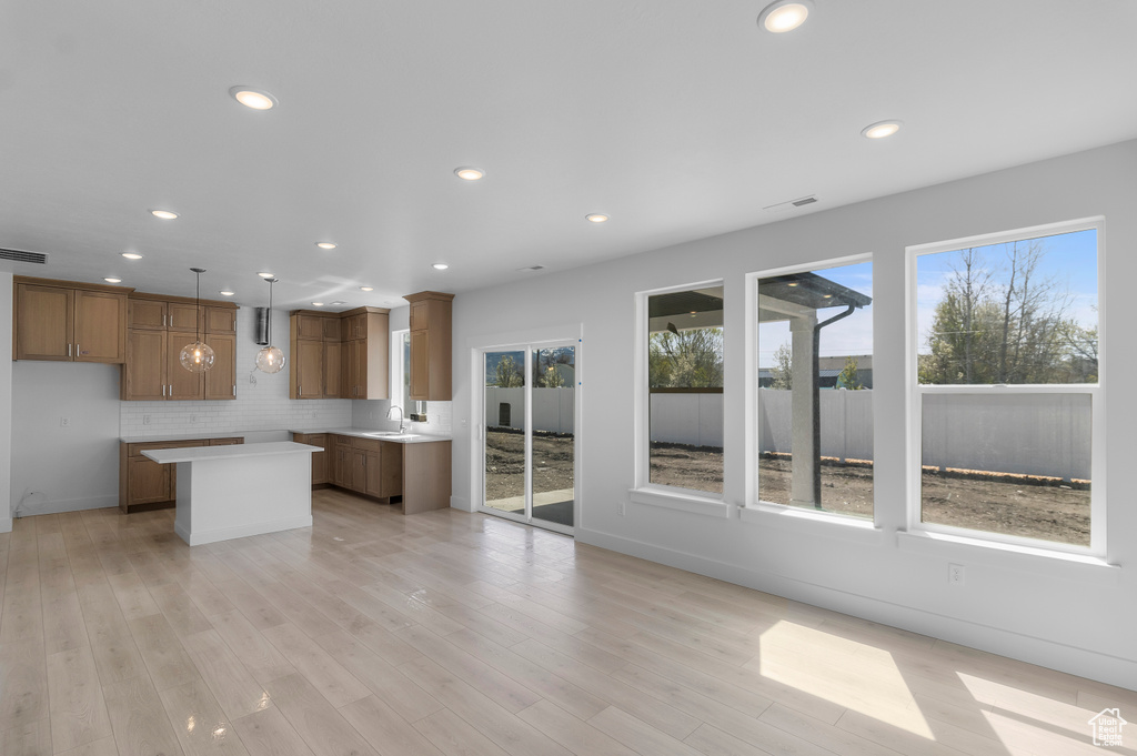 Interior space with a sink, visible vents, baseboards, light wood-type flooring, and recessed lighting
