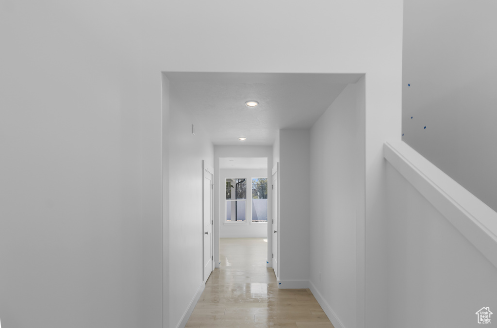 Corridor featuring baseboards, recessed lighting, and light wood finished floors
