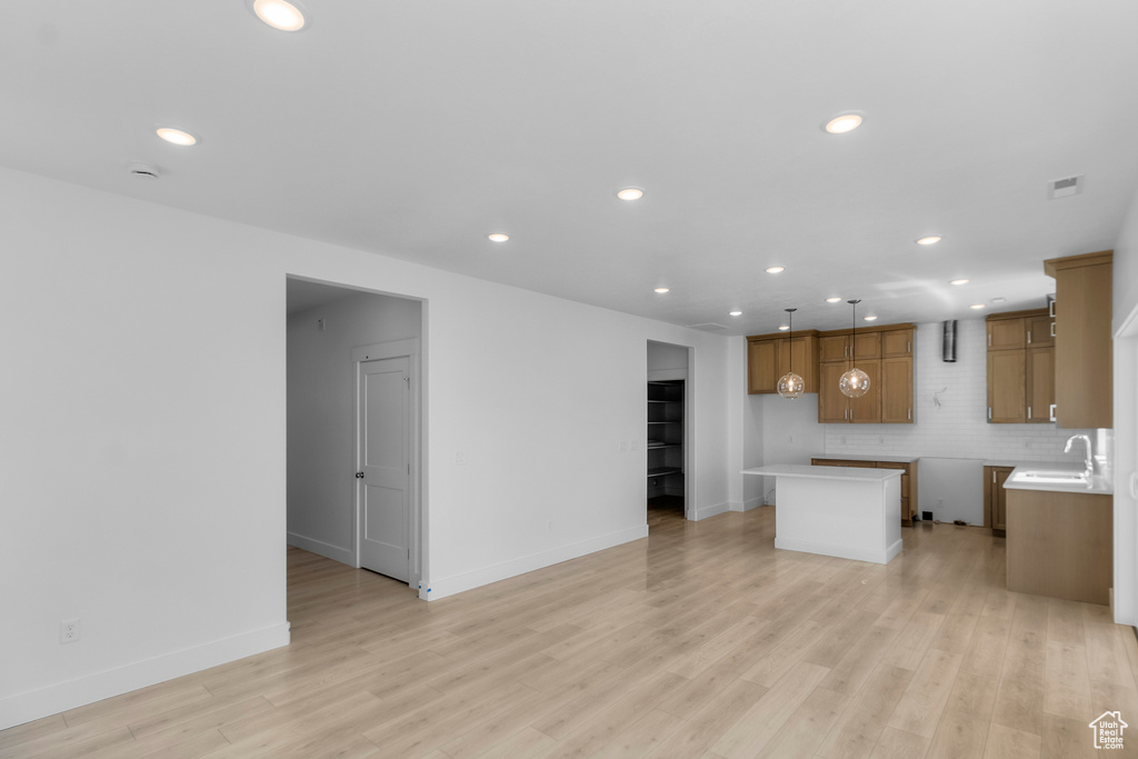 Kitchen featuring recessed lighting, a sink, brown cabinetry, and light wood-style floors
