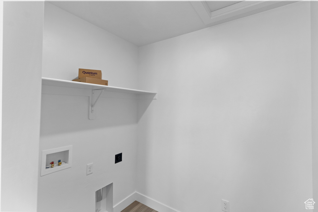 Laundry room with hookup for an electric dryer, baseboards, hookup for a washing machine, wood finished floors, and laundry area