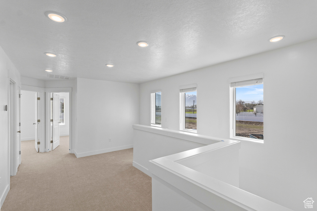 Hall with visible vents, recessed lighting, light carpet, and baseboards