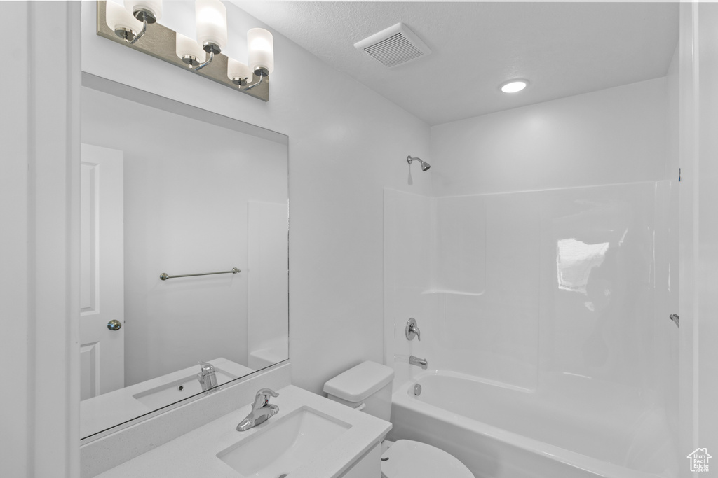 Full bath featuring visible vents, toilet,  shower combination, and vanity