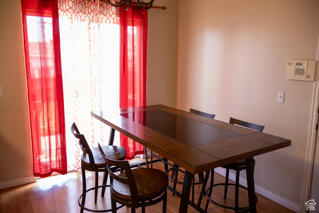 Dining room featuring a chandelier, wood finished floors, and baseboards
