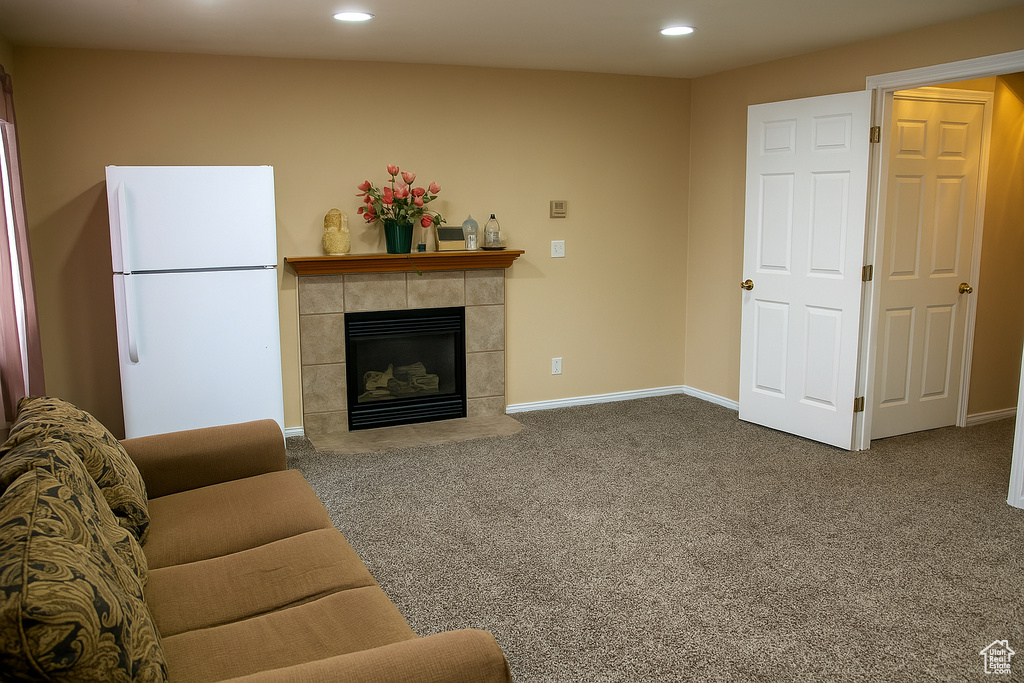 Carpeted living room featuring a fireplace, baseboards, and recessed lighting