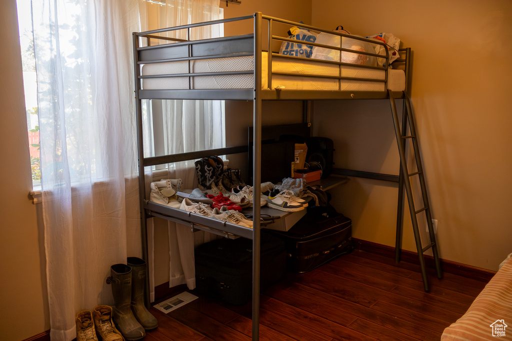 Bedroom featuring wood finished floors, baseboards, and visible vents