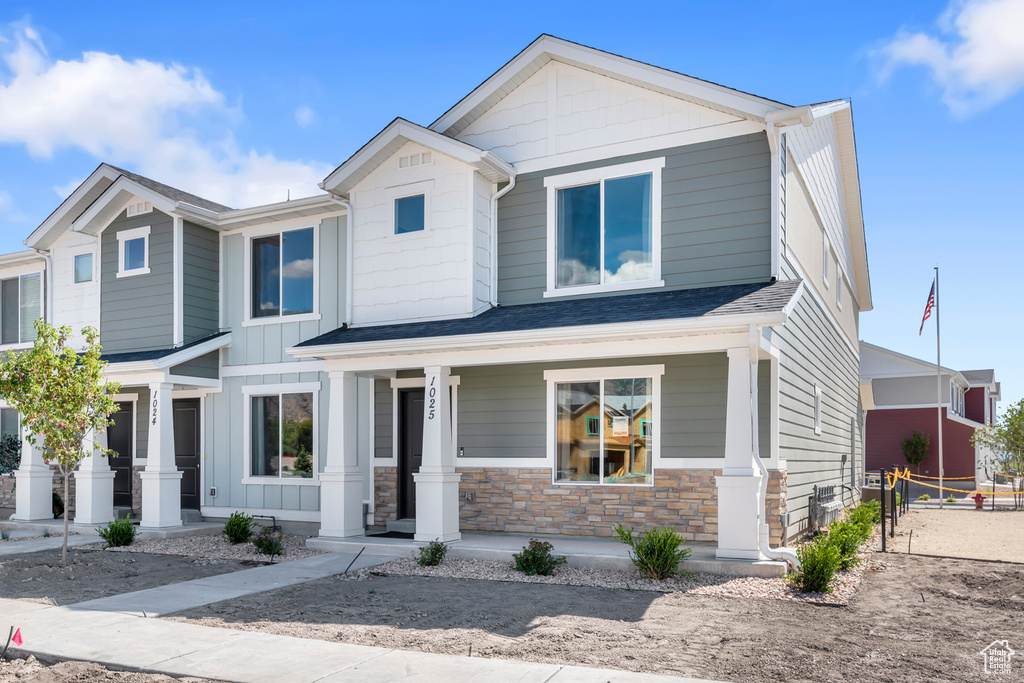 Craftsman-style house with board and batten siding, covered porch, and stone siding