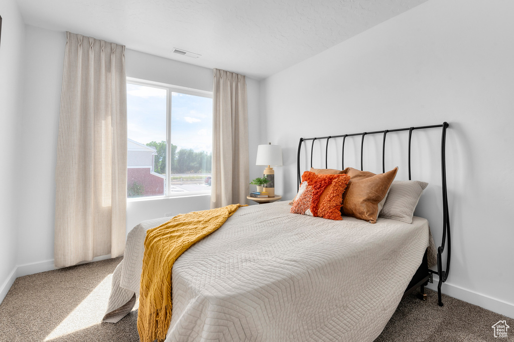Bedroom featuring carpet flooring, baseboards, and visible vents