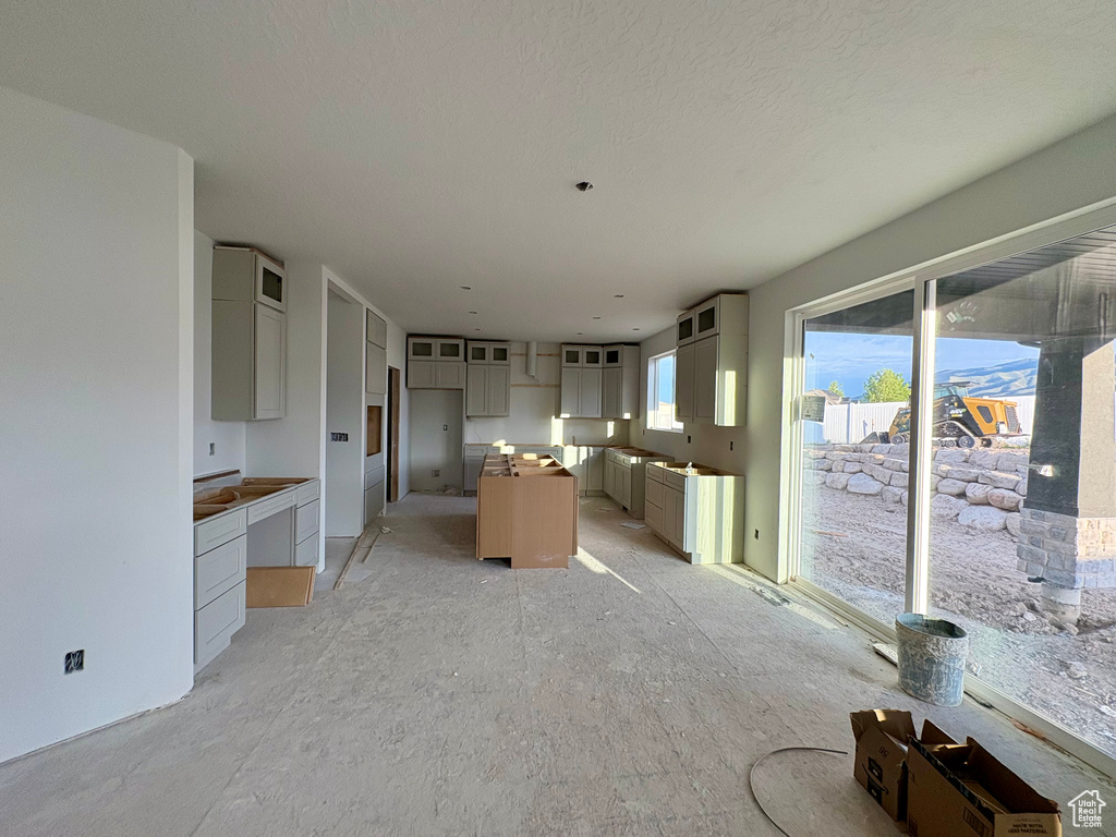 Kitchen featuring a center island, glass insert cabinets, and gray cabinets
