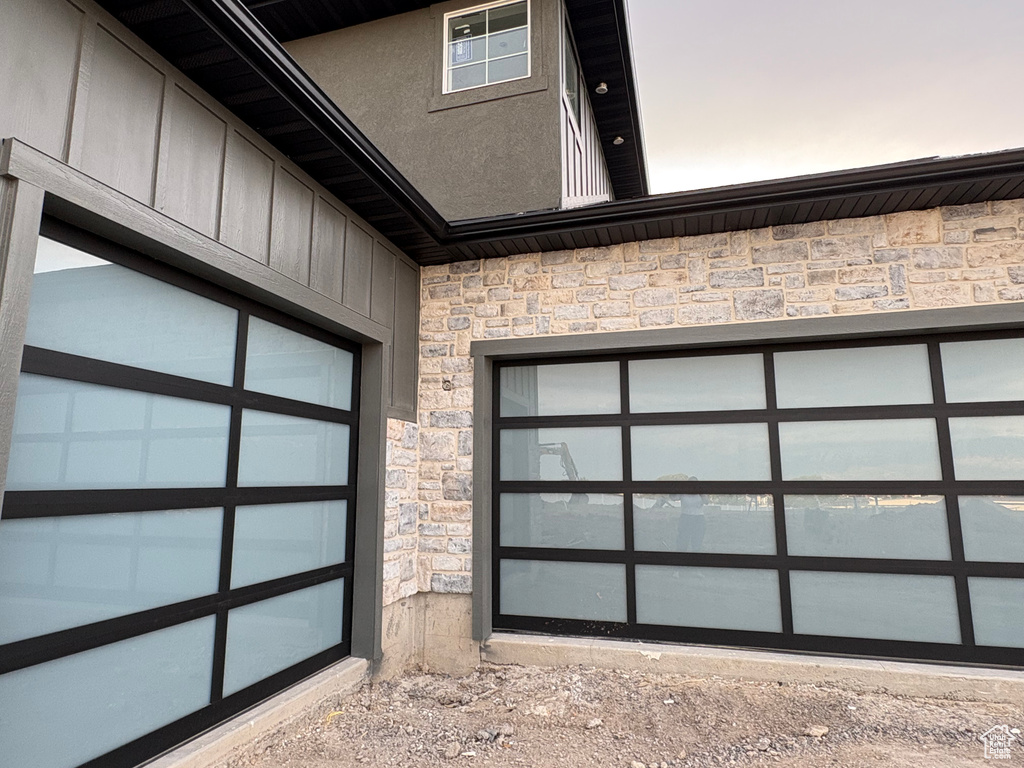 Exterior view of stone siding, driveway, and board and batten siding