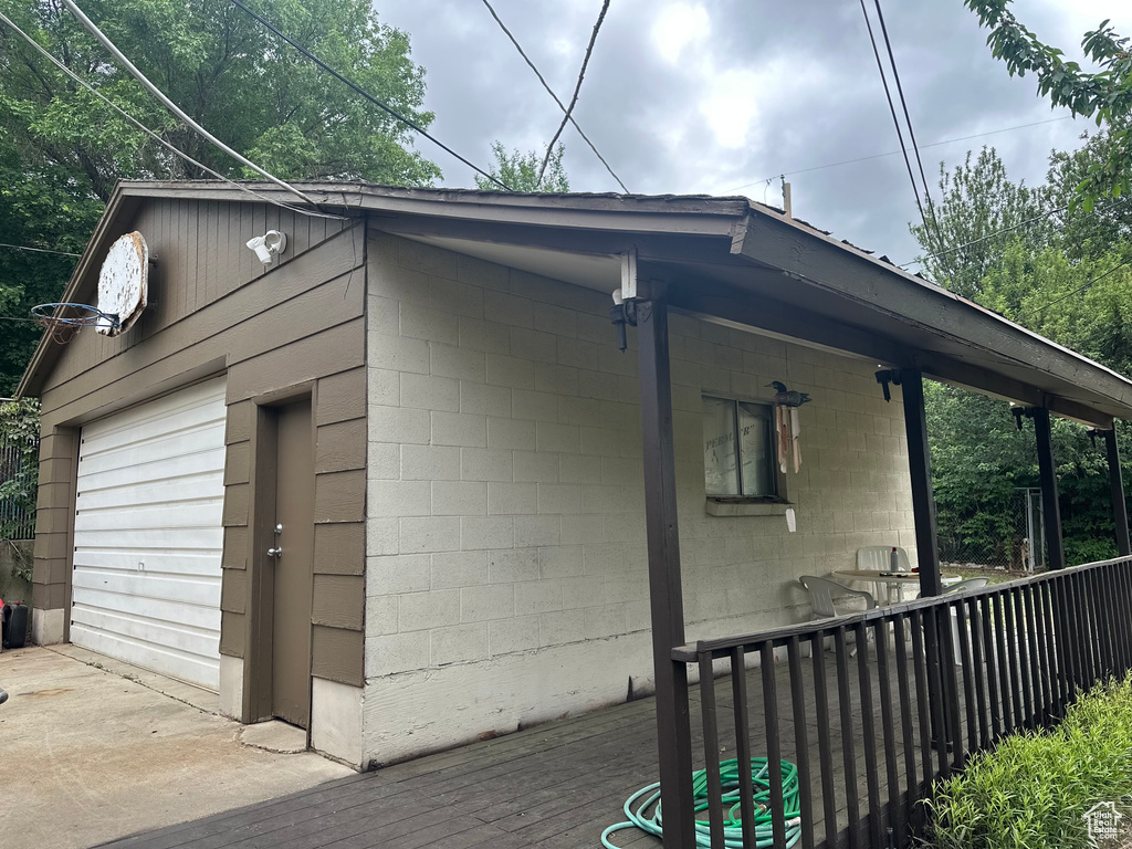 View of home\\\\\\\'s exterior featuring concrete block siding, a deck, and an outdoor structure
