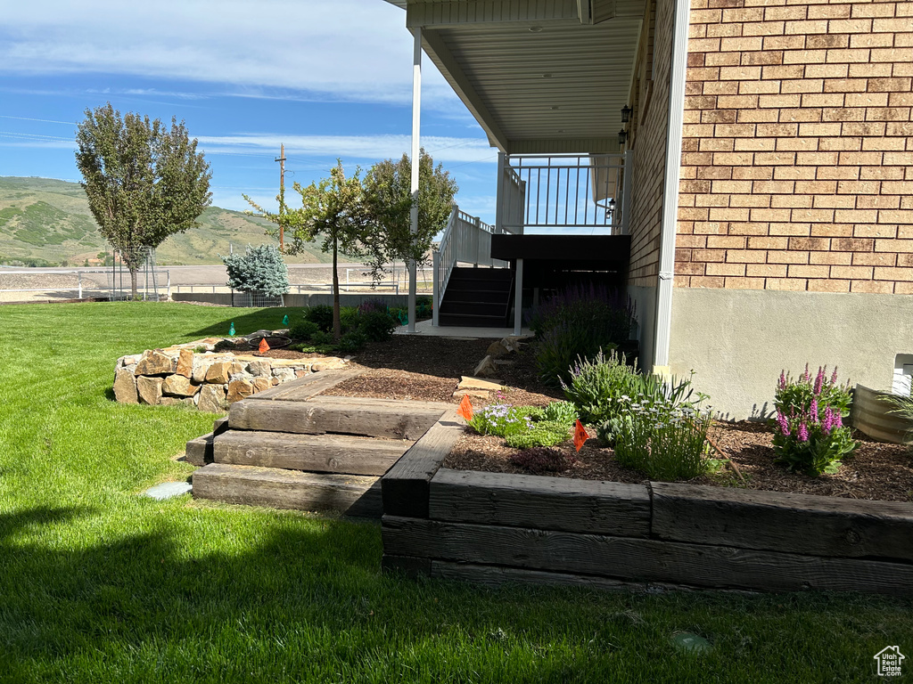 View of green lawn featuring stairway and a mountain view