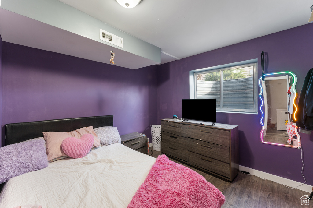 Bedroom featuring wood finished floors, baseboards, and visible vents
