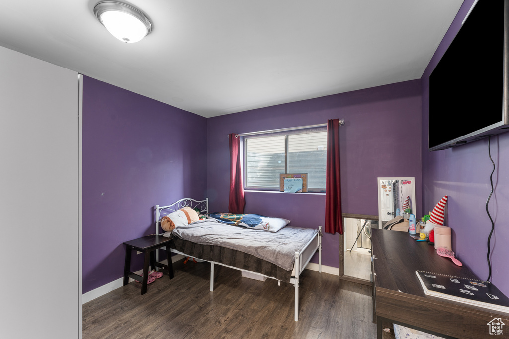 Bedroom with wood finished floors and baseboards