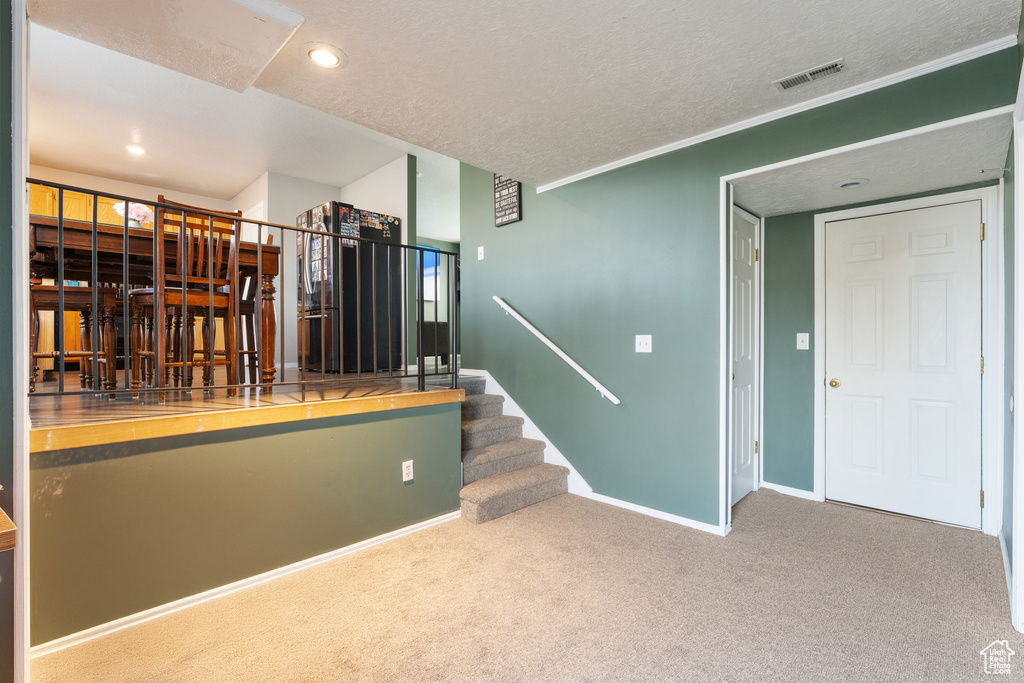 Stairs with baseboards, recessed lighting, carpet flooring, a textured ceiling, and visible vents